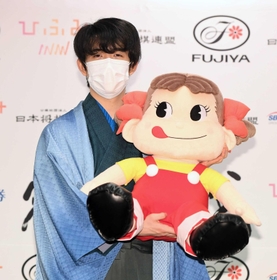 史上最年少で三冠を達成し、叡王戦スポンサーのマスコット人形を手にする藤井聡太三冠＝１３日夜、東京都渋谷区