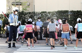 横断歩道で児童を見守る垂水署員＝神戸市垂水区舞多聞西５