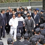 工藤会関係先を家宅捜索する福岡県警捜査員と野村悟被告（中央左、白色の服装）