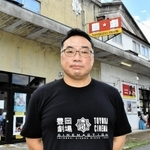 築９４年になる豊岡劇場の前に立つ石橋秀彦代表＝豊岡市元町