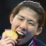 ロンドン五輪のレスリング女子で３連覇し、金メダルにかぶりつくように口を開ける吉田沙保里＝２０１２年８月、英国・エクセル