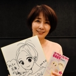 リスナーへのプレゼントのサイン色紙と単行本を持つひうらさとるさん＝豊岡市内