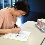 ボイシーのリスナープレゼント用にサインを書くひうらさとるさん＝豊岡市内