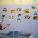 湯船に漬かって展示作品を紹介する田岡和也さん＝神戸市兵庫区笠松通６、笠松湯