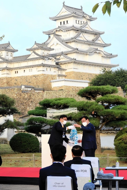 清元秀泰・姫路市長（左）から「千羽鷺」を受け取る後藤茂之・厚生労働相＝２４日午後、姫路市本町、姫路城西の丸庭園（撮影・大山伸一郎）