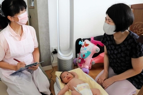 自宅で産後ケアを受けた女性（右）。助産師から生活実態に即した助言を得た＝神戸市須磨区