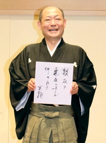 桂米朝さんの俳句を手にし、襲名披露公演をＰＲする八十八さん＝神戸新開地・喜楽館