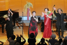 稲の束を手にする加藤登紀子さん＝兵庫県多可町中区中村町