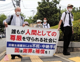 横断幕を手に神戸地裁に入場する強制不妊訴訟の原告団たち＝８月３日、神戸市中央区橘通２