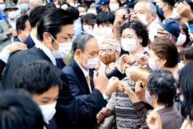 演説後に有権者とグータッチをする菅義偉前首相（中央）＝１６日午後、宝塚市栄町２、阪急宝塚駅前（撮影・斎藤雅志）