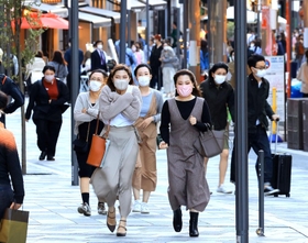 冷たい風が吹く中、背中を丸めて歩く人たち＝１７日午後、神戸市中央区加納町４（撮影・小林良多）