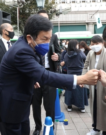 有権者とグータッチをし、支持を訴える立憲民主党の枝野幸男代表（左）＝２４日午後、神戸市中央区