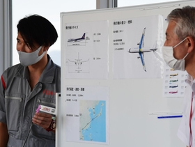 図を用いて飛行機の仕組みを説明するＦＤＡの整備士（左）＝神戸市中央区、神戸空港