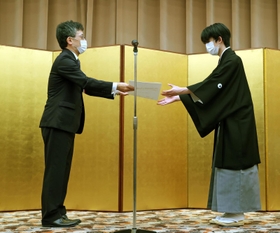 第６２期王位就位式で就位状を受け取る藤井聡太王位。左は日本将棋連盟の佐藤康光会長＝２８日午後、東京都千代田区（代表撮影）