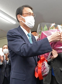 支持者から花束を贈られ、グータッチをして喜ぶ渡海紀三朗氏＝加古川市加古川町粟津（撮影・笠原次郎）