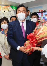 花束を受け取り、支援者とともに喜ぶ赤羽一嘉氏＝神戸市兵庫区水木通８（撮影・鈴木雅之）
