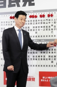 ７選を確実にし、自分の名前に花を付ける西村康稔氏＝東京・永田町、自民党本部（撮影・永見将人）