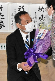 支援者から花束を受け取り、当選を喜ぶ藤井比早之氏＝西脇市野村町