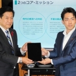 小泉進次郎前環境省からタブレットを引き継ぐ山口壮新環境相（左）＝東京都千代田区