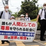 横断幕を手に神戸地裁に入場する強制不妊訴訟の原告団たち＝８月３日、神戸市中央区橘通２