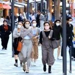 冷たい風が吹く中、背中を丸めて歩く人たち＝１７日午後、神戸市中央区加納町４（撮影・小林良多）