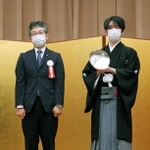 第６２期王位就位式で王位杯を手にする藤井聡太王位。左は日本将棋連盟の佐藤康光会長＝２８日午後、東京都千代田区（代表撮影）