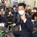選挙区を駆け回った自転車にまたがり当選を喜ぶ井坂信彦氏＝神戸市中央区八幡通４（撮影・小林良多）