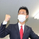 選挙区を駆け回った自転車にまたがり当選確実を喜ぶ井坂信彦氏＝神戸市中央区八幡通４（撮影・小林良多）
