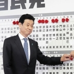７選を確実にし、自分の名前に花を付ける西村康稔氏＝東京・永田町、自民党本部（撮影・永見将人）