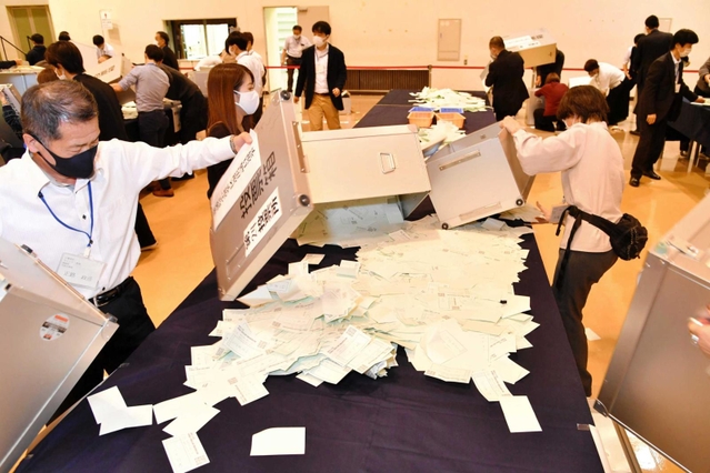 開披台の上に広げられる衆院選小選挙区の投票用紙＝神戸市中央区港島中町６、神戸国際展示場（撮影・三津山朋彦）