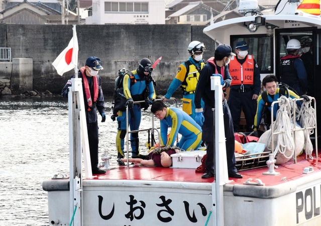 要救助者に見立てた人形を海から引き揚げ、心肺蘇生を試みる警察官と海上保安官ら＝２日午前、南あわじ市沼島