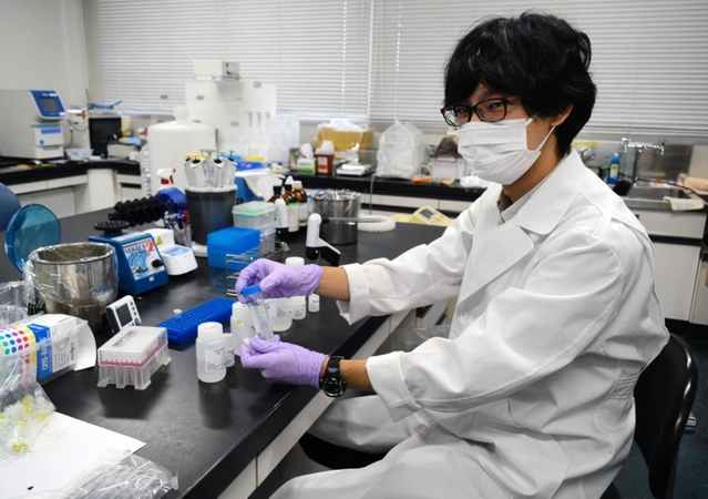 下水中のウイルス関連物質を見つける作業手順を示す谷本佳彦研究員＝神戸市中央区港島中町４