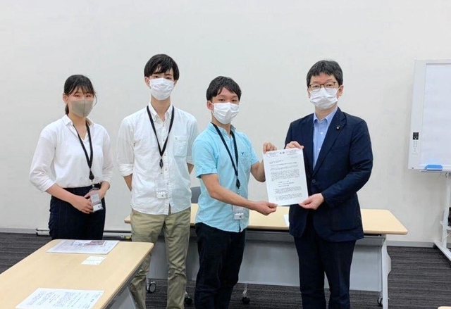 ミャンマーの民主化を推進する議員連盟の石橋通宏参院議員（右）に避難民への人道支援などを求める嘆願書を提出する山田純さん（右から２人目）らインターン生＝７月、東京都内（山田さん提供）