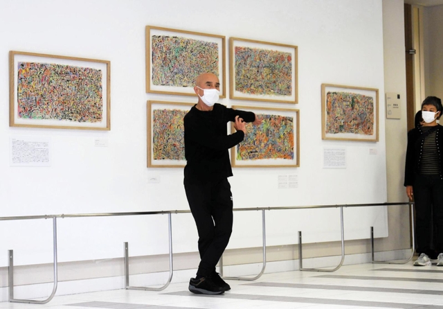 富塚純光さんの作品の前で踊る岩下さん＝神戸市東灘区岡本８、甲南大学岡本キャンパス