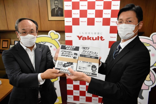 兵庫県警の田村隆清犯罪抑止対策官（右）からチラシを受け取る谷川清十郎社長＝神戸市中央区熊内町５