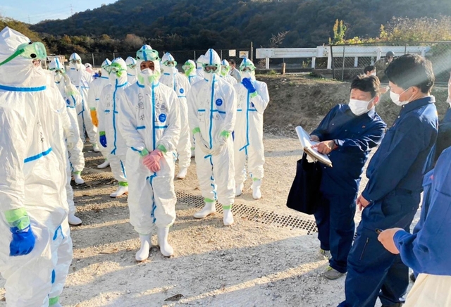 養鶏場で殺処分作業に当たる県職員らから状況を聞き取る兵庫県の斎藤元彦知事（右端）＝姫路市内（県提供）