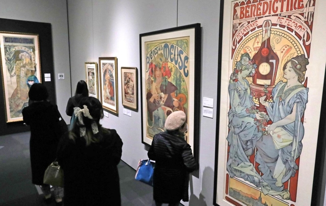 緻密で繊細なミュシャの作品に見入る来場者ら＝神戸市東灘区向洋町中２、神戸ファッション美術館（撮影・長嶺麻子）