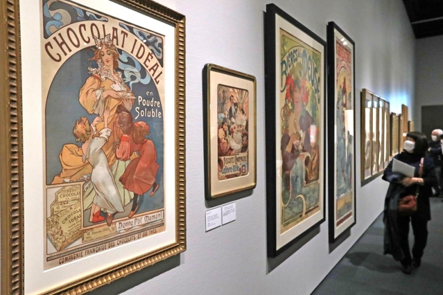 緻密で繊細なミュシャの作品に見入る来場者ら＝神戸市東灘区向洋町中２、神戸ファッション美術館（撮影・長嶺麻子）