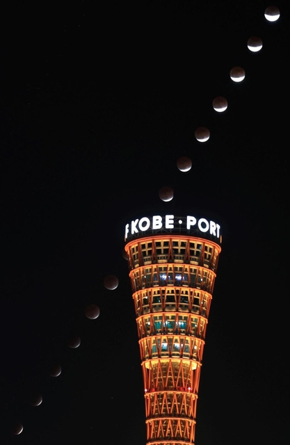 ほぼ皆既食となった月＝１９日夜、神戸市中央区（５分おきに撮影した１５枚を比較明合成、撮影・吉田敦史）