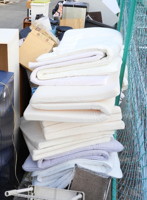 風俗営業に使われていた布団やマットレスなど、店の備品が粗大ゴミとして山積み＝１６日午後、尼崎市神田南通３