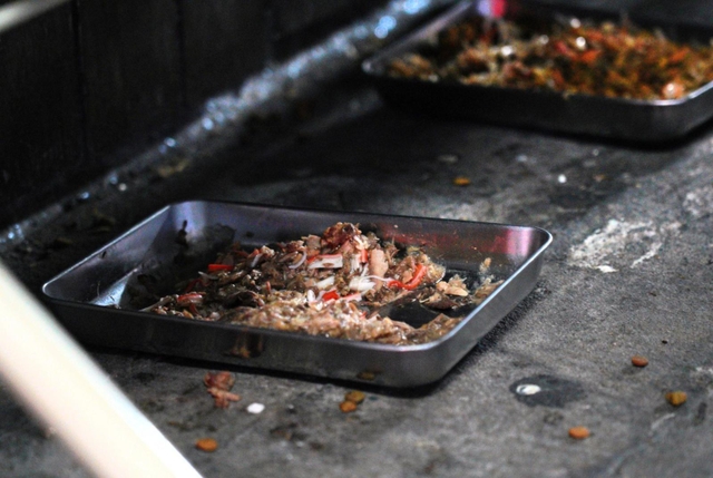 かんなみ新地の敷地内に置かれた「地域ネコ」のエサ。よく食べるよう「かにかま」が混ぜられている。地元ボランティアと協力して面倒を見ているといい、警告を受けて廃業してからもママさんがエサをやりにきている。緊急事態宣言発令により休業している間も、エサの交換は欠かさなかった＝５日夜、尼崎市神田南通３