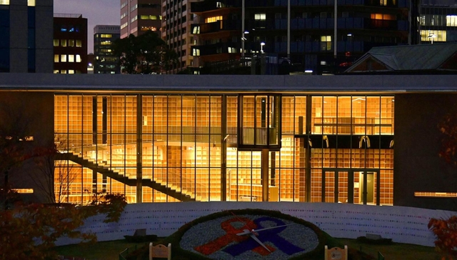 日が沈むと内部の明かりで浮かび上がる「こども本の森　神戸」の本棚＝神戸市中央区加納町６