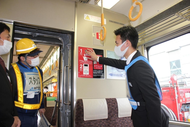 車内の非常ボタンを押す参加者＝３０日午後０時１８分、兵庫県太子町、網干総合車両所