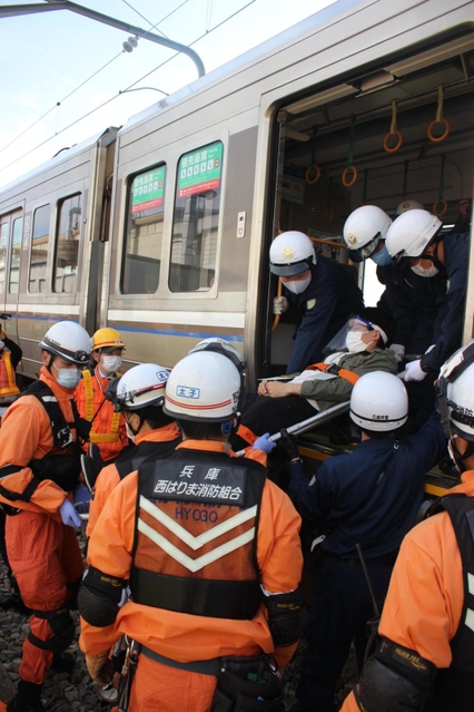 列車のドアから線路への避難を体験する参加者＝兵庫県太子町