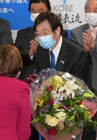 当選確実の知らせを受け、祝いの花束を受け取る久元喜造氏＝神戸市中央区御幸通８（撮影・秋山亮太）