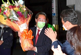 接戦を制し、花束を掲げて喜ぶ日本維新の会の市村浩一郎氏＝宝塚市逆瀬川２（撮影・中西幸大）