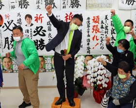 拳を突き上げて喜びをかみしめる遠藤良太氏＝三田市中央町（撮影・土井秀人）
