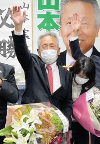 たつの市長選で当選確実の報道を受け、万歳する現職・山本実氏＝たつの市龍野町富永の事務所