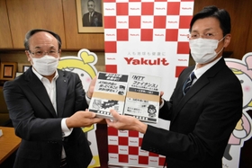 兵庫県警の田村隆清犯罪抑止対策官（右）からチラシを受け取る谷川清十郎社長＝神戸市中央区熊内町５