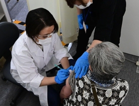 ずらりと並ぶブース内でワクチン接種を受ける高齢者ら＝５月、神戸市内